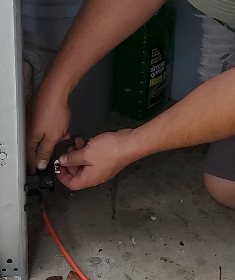 Technician aligning garage door sensor