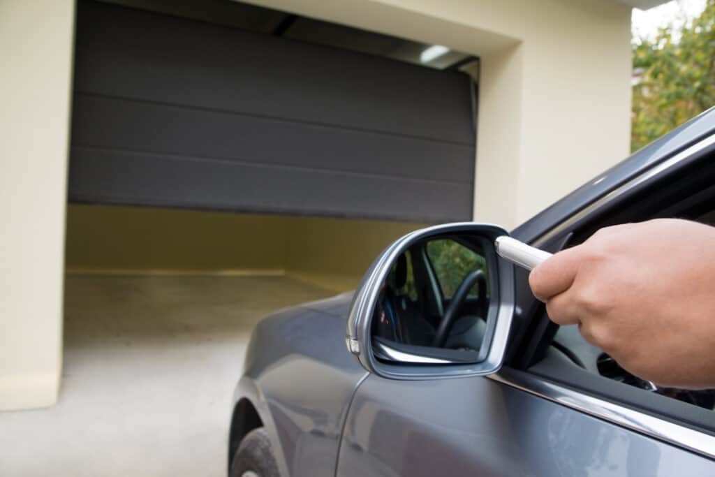 Driver uses remote to open garage door from the car